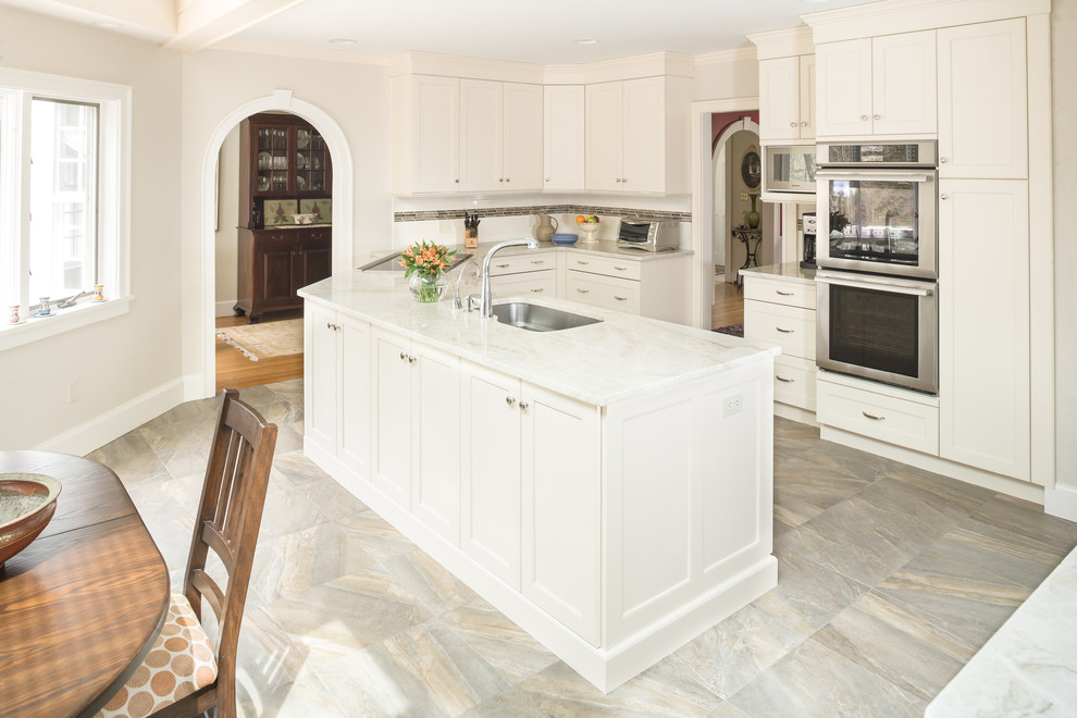 Eat-in kitchen - mid-sized traditional l-shaped ceramic tile eat-in kitchen idea in New York with an undermount sink, shaker cabinets, white cabinets, marble countertops, white backsplash, subway tile backsplash, stainless steel appliances and no island