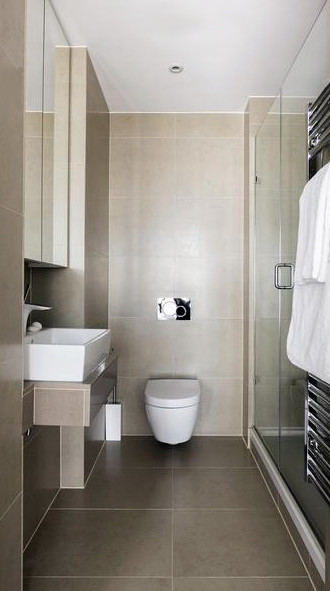 Design ideas for a contemporary bathroom in London with a console sink, glass-front cabinets, white cabinets, limestone benchtops, a double shower, a wall-mount toilet, beige tile, beige walls and limestone floors.