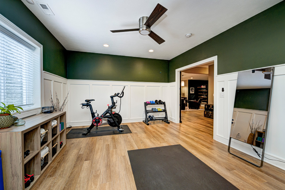 Design ideas for a mid-sized contemporary multipurpose gym in Indianapolis with multi-coloured walls, medium hardwood floors and beige floor.