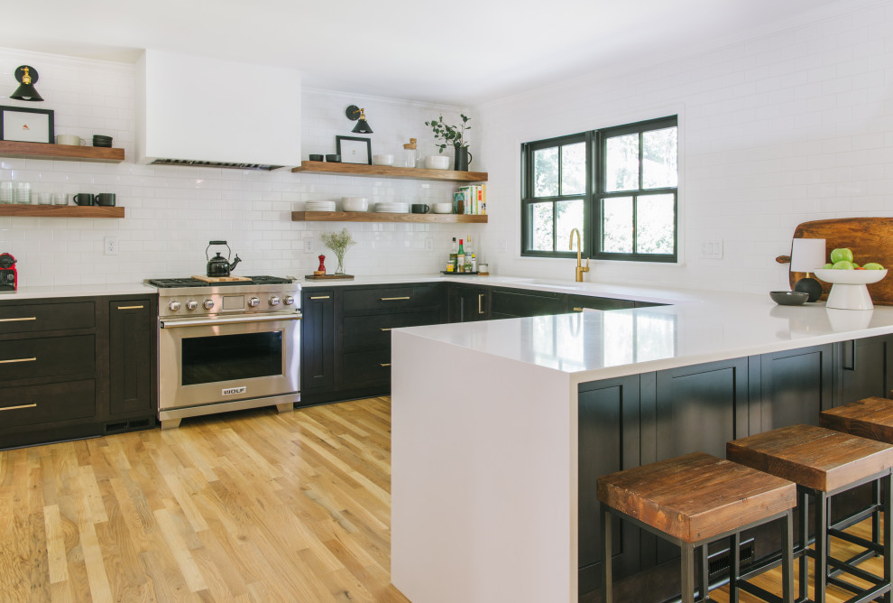 Inspiration for a mid-sized transitional u-shaped eat-in kitchen remodel in Atlanta with shaker cabinets, dark wood cabinets, white backsplash, subway tile backsplash, stainless steel appliances, a peninsula and white countertops