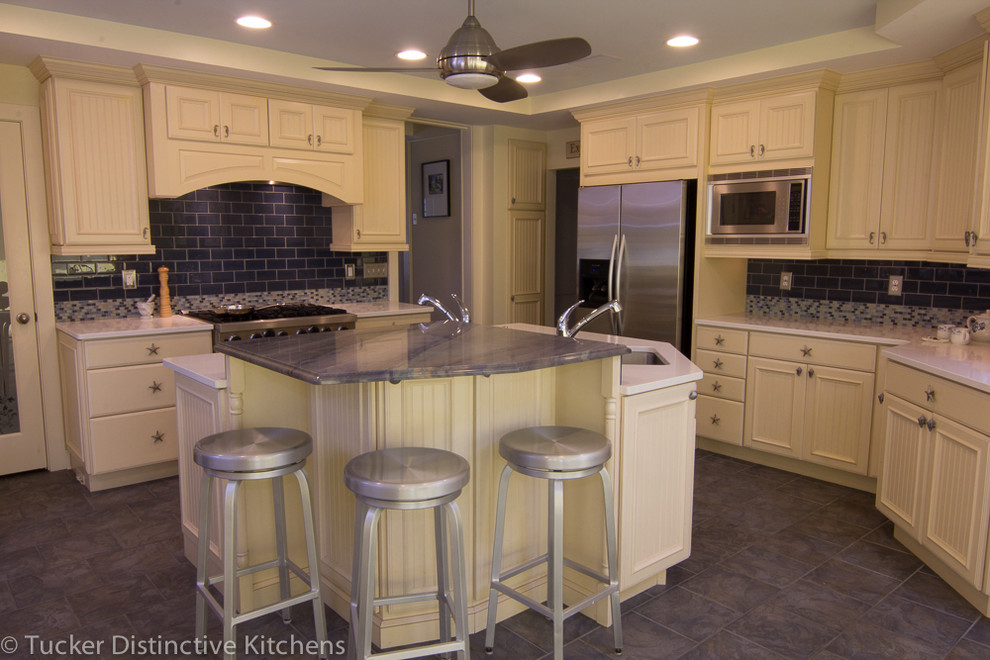 Photo of a beach style kitchen in Charleston with beaded inset cabinets, yellow cabinets, quartzite benchtops, blue splashback, stainless steel appliances and with island.