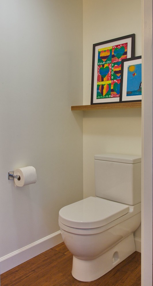 This is an example of a small contemporary powder room in San Francisco with flat-panel cabinets, medium wood cabinets, a two-piece toilet, white walls, bamboo floors, a drop-in sink, brown floor and beige benchtops.