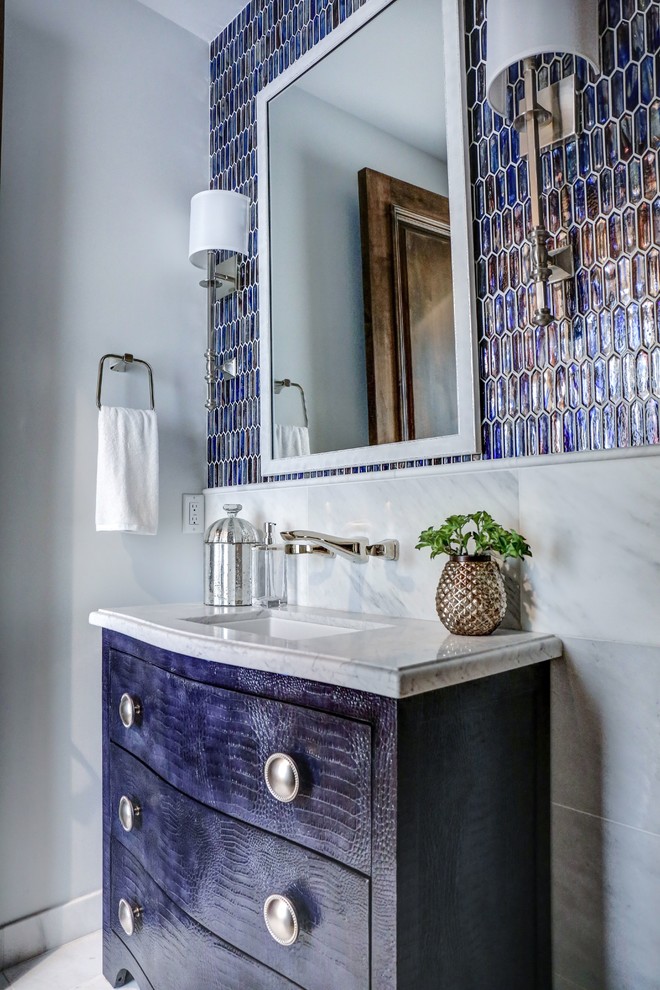 Photo of a large contemporary powder room in Phoenix with furniture-like cabinets, blue cabinets, a one-piece toilet, blue tile, mosaic tile, white walls, ceramic floors, an integrated sink, marble benchtops, white floor and white benchtops.