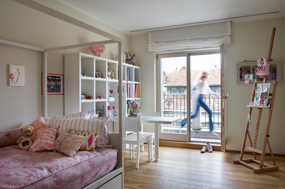 Large contemporary kids' bedroom in Milan with beige walls and light hardwood floors for kids 4-10 years old and girls.