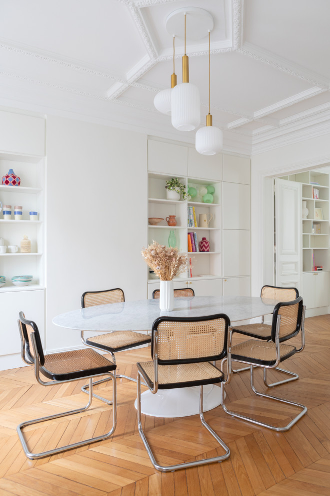 Photo of a large scandinavian kitchen/dining room in Paris with white walls and light hardwood flooring.
