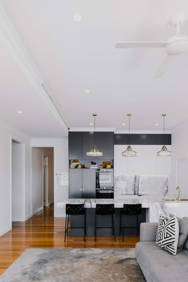 Inspiration for a mid-sized contemporary galley open plan kitchen in Brisbane with an undermount sink, flat-panel cabinets, black cabinets, grey splashback, panelled appliances, medium hardwood floors, with island, brown floor and grey benchtop.