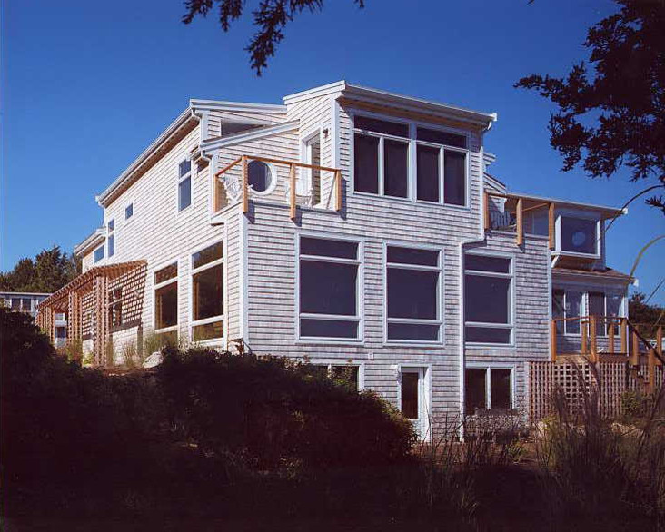 This is an example of a mid-sized beach style two-storey beige exterior in New York with wood siding and a gable roof.