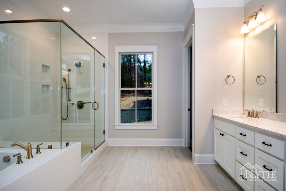 Amerikansk inredning av ett mellanstort beige beige en-suite badrum, med skåp i shakerstil, vita skåp, ett platsbyggt badkar, vit kakel, tunnelbanekakel, grå väggar, ett undermonterad handfat, bänkskiva i kvarts, grått golv och dusch med gångjärnsdörr