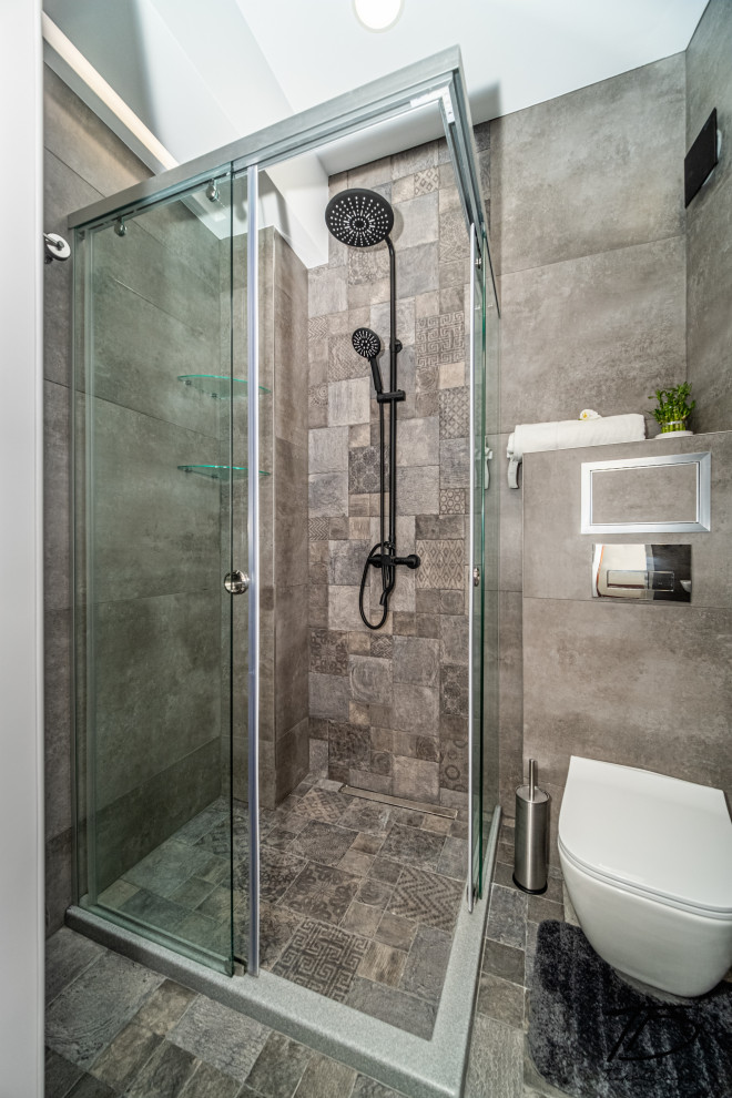 Design ideas for a small industrial 3/4 bathroom in Other with a corner shower, a wall-mount toilet, gray tile, ceramic tile, terra-cotta floors, a wall-mount sink, grey floor, a sliding shower screen, a niche and a single vanity.