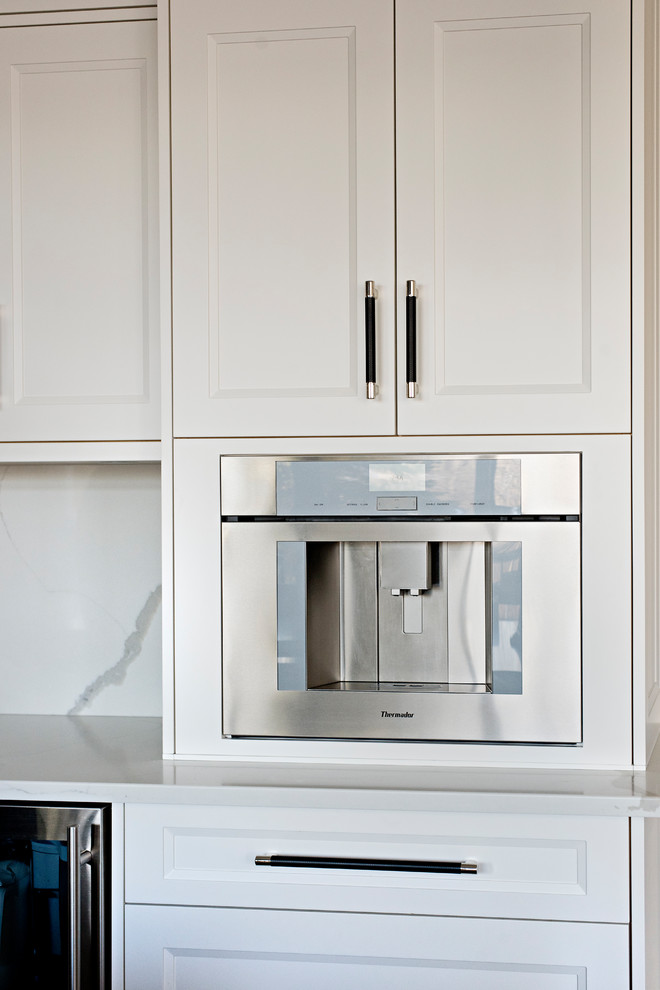 Inspiration for a large transitional l-shaped medium tone wood floor and brown floor open concept kitchen remodel in Toronto with an undermount sink, recessed-panel cabinets, white cabinets, white backsplash, paneled appliances, an island, white countertops, quartz countertops and marble backsplash