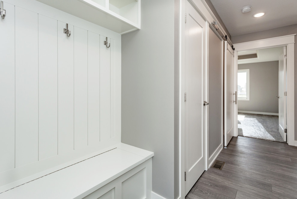 Inspiration for a mid-sized transitional medium tone wood floor and brown floor hallway remodel with gray walls