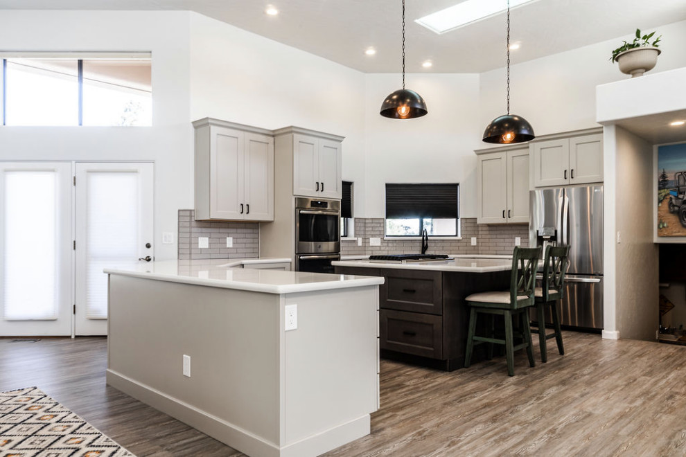 Inspiration for a large transitional u-shaped vinyl floor and gray floor eat-in kitchen remodel with an undermount sink, shaker cabinets, gray cabinets, quartzite countertops, green backsplash, subway tile backsplash, stainless steel appliances, an island and white countertops