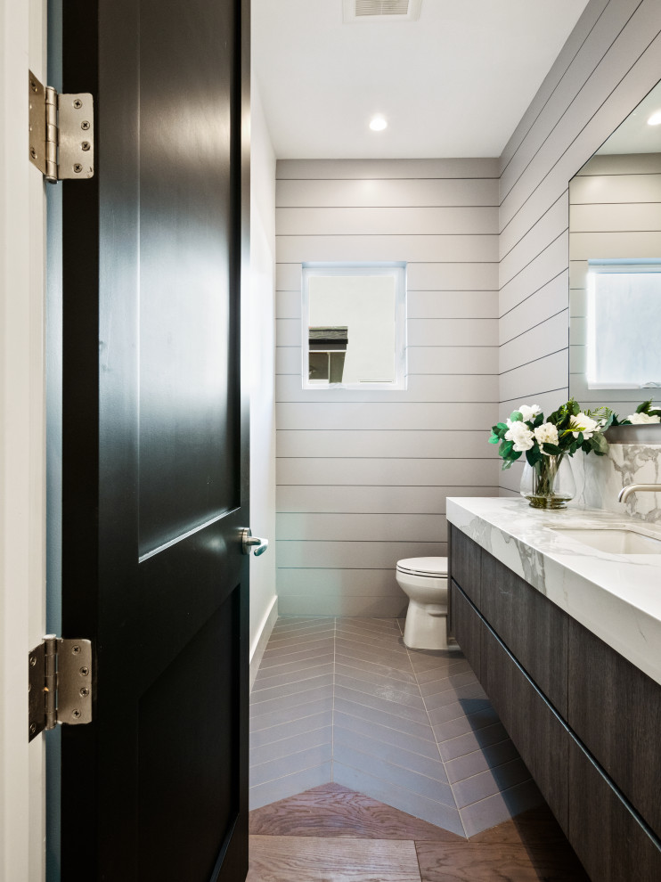 Photo of a mid-sized country powder room in Los Angeles with dark wood cabinets, grey walls, an undermount sink, marble benchtops, multi-coloured benchtops, a floating vanity and panelled walls.