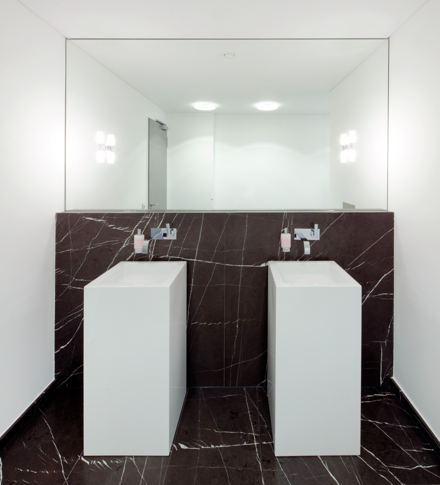 This is an example of a mid-sized contemporary bathroom in Dusseldorf with black tile, stone slab, white walls, marble floors and a pedestal sink.