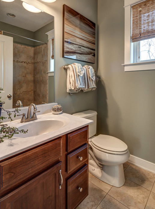 Mid-sized beach style bathroom in Other with an undermount sink, recessed-panel cabinets, medium wood cabinets, granite benchtops, a shower/bathtub combo, a one-piece toilet, beige tile, ceramic tile, beige walls and medium hardwood floors.