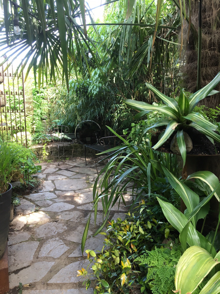 Idee per un piccolo giardino boho chic in ombra dietro casa con un muro di contenimento e pavimentazioni in pietra naturale