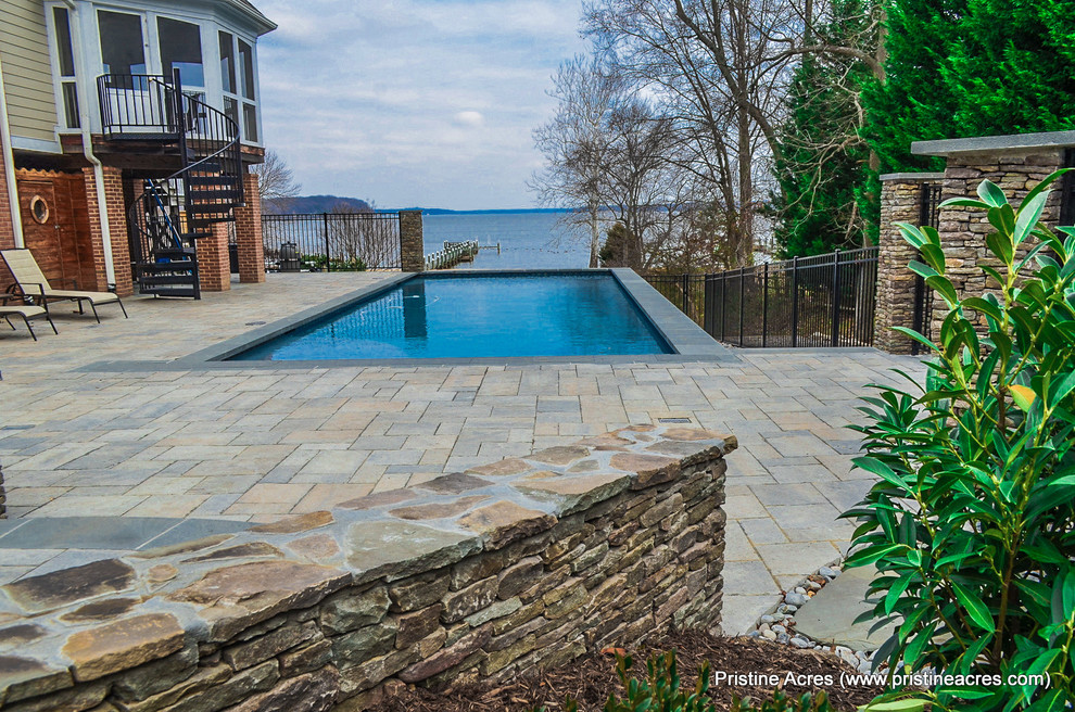 Huge transitional backyard concrete paver and rectangular lap pool photo in DC Metro