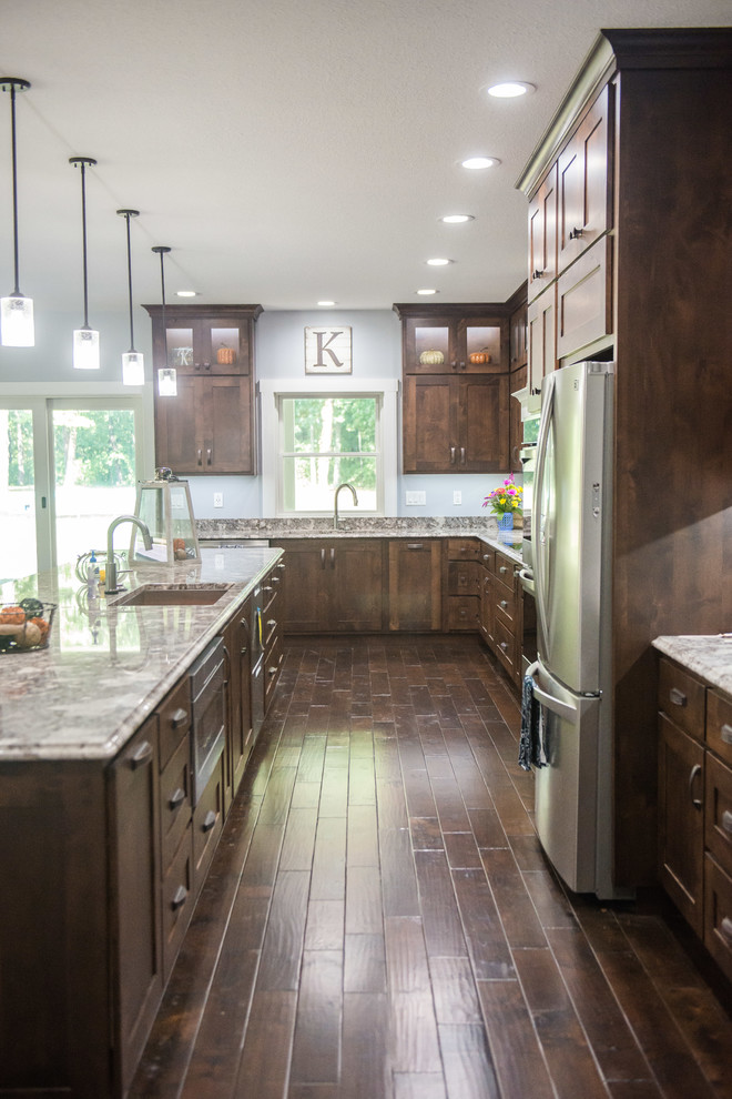 Inspiration for a transitional l-shaped open concept kitchen remodel with an undermount sink, shaker cabinets, dark wood cabinets, granite countertops, stainless steel appliances, an island and multicolored countertops
