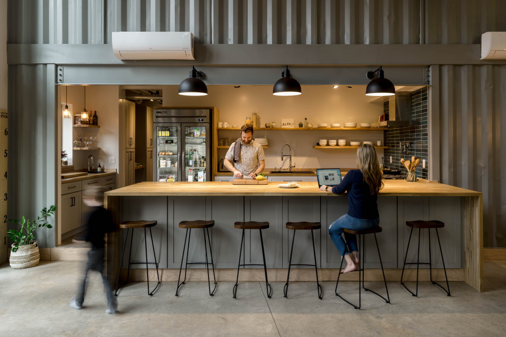 Design ideas for an urban kitchen in Seattle with wood worktops, blue splashback, ceramic splashback, stainless steel appliances, concrete flooring and grey floors.