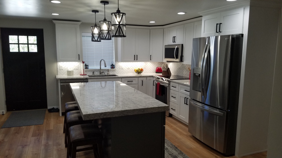Large contemporary l-shaped eat-in kitchen in Boise with shaker cabinets, white cabinets, quartz benchtops, white splashback, stainless steel appliances, with island and grey benchtop.