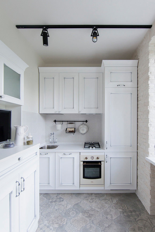 This is an example of a contemporary single-wall separate kitchen in Moscow with an undermount sink, recessed-panel cabinets, white cabinets, white splashback, white appliances, no island and grey floor.