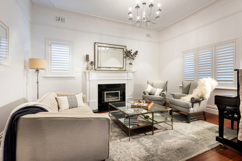 This is an example of a transitional living room in Perth with white walls, dark hardwood floors, a standard fireplace and no tv.
