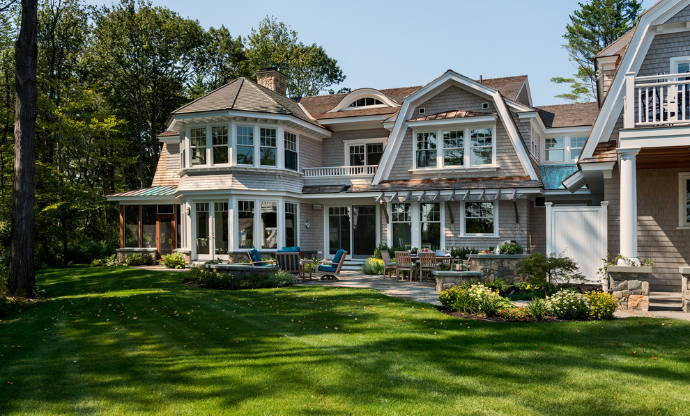 This is an example of a large beach style two-storey grey house exterior in Boston with wood siding, a gambrel roof and a shingle roof.