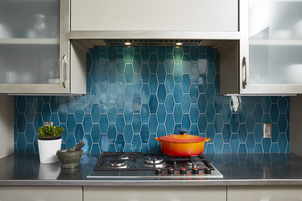 This is an example of a midcentury kitchen in Minneapolis with glass-front cabinets, blue splashback and porcelain splashback.