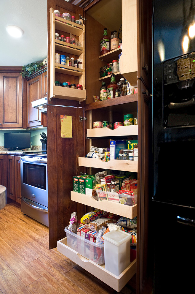 Small transitional l-shaped medium tone wood floor eat-in kitchen photo with an undermount sink, raised-panel cabinets, medium tone wood cabinets, laminate countertops, blue backsplash, black appliances and an island