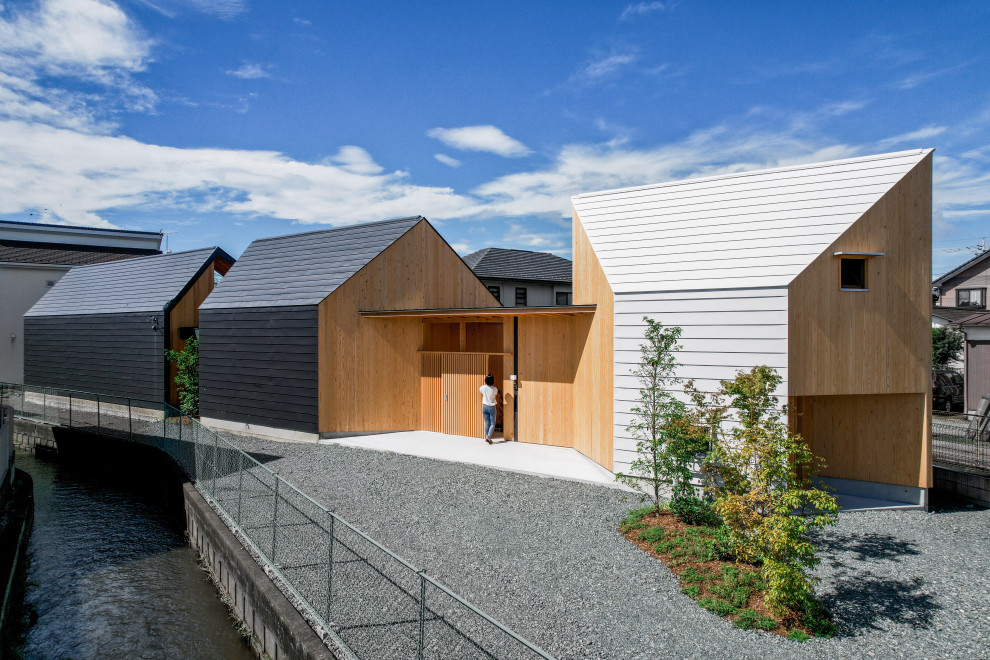 Imagen de fachada de casa blanca y blanca minimalista de tamaño medio de una planta con revestimiento de madera, tejado a dos aguas y tejado de metal
