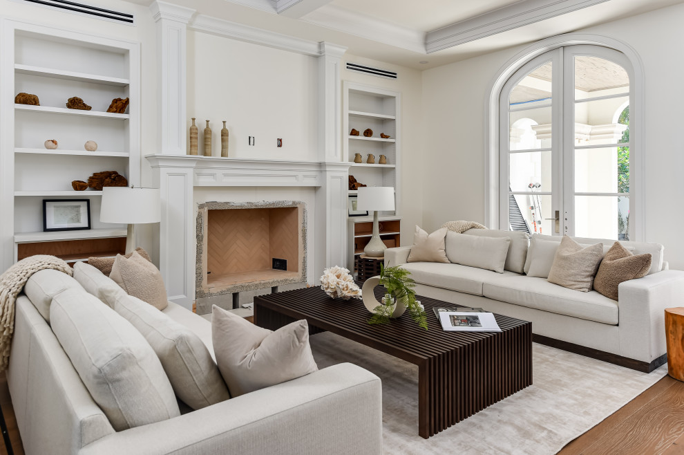Cette image montre un grand salon traditionnel ouvert avec un mur blanc, parquet foncé, une cheminée standard, un manteau de cheminée en pierre, un téléviseur encastré, un sol marron et un plafond décaissé.
