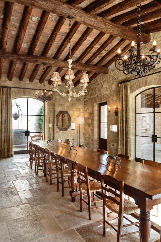 Large mediterranean open plan dining in Orange County with limestone floors, beige walls and beige floor.