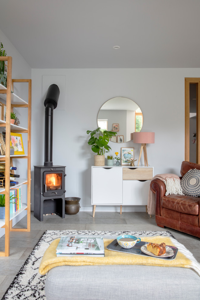 Photo of a medium sized scandinavian living room in Sussex with white walls, a wood burning stove and grey floors.
