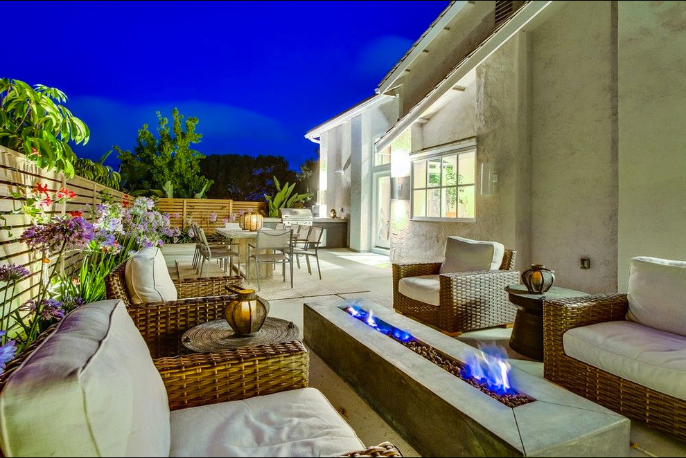 Photo of a large contemporary backyard patio in San Diego with a fire feature, concrete slab and no cover.