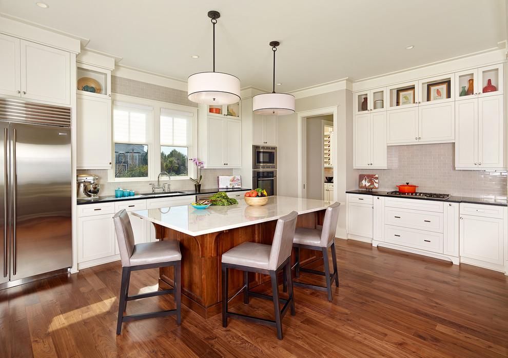 Inspiration for a coastal l-shaped open concept kitchen remodel in Charleston with recessed-panel cabinets, white cabinets, gray backsplash and stainless steel appliances