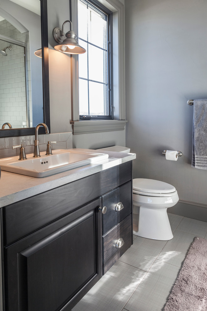 Transitional medium tone wood floor bathroom photo in Denver with raised-panel cabinets, white backsplash, subway tile backsplash, a drop-in sink, dark wood cabinets and quartzite countertops