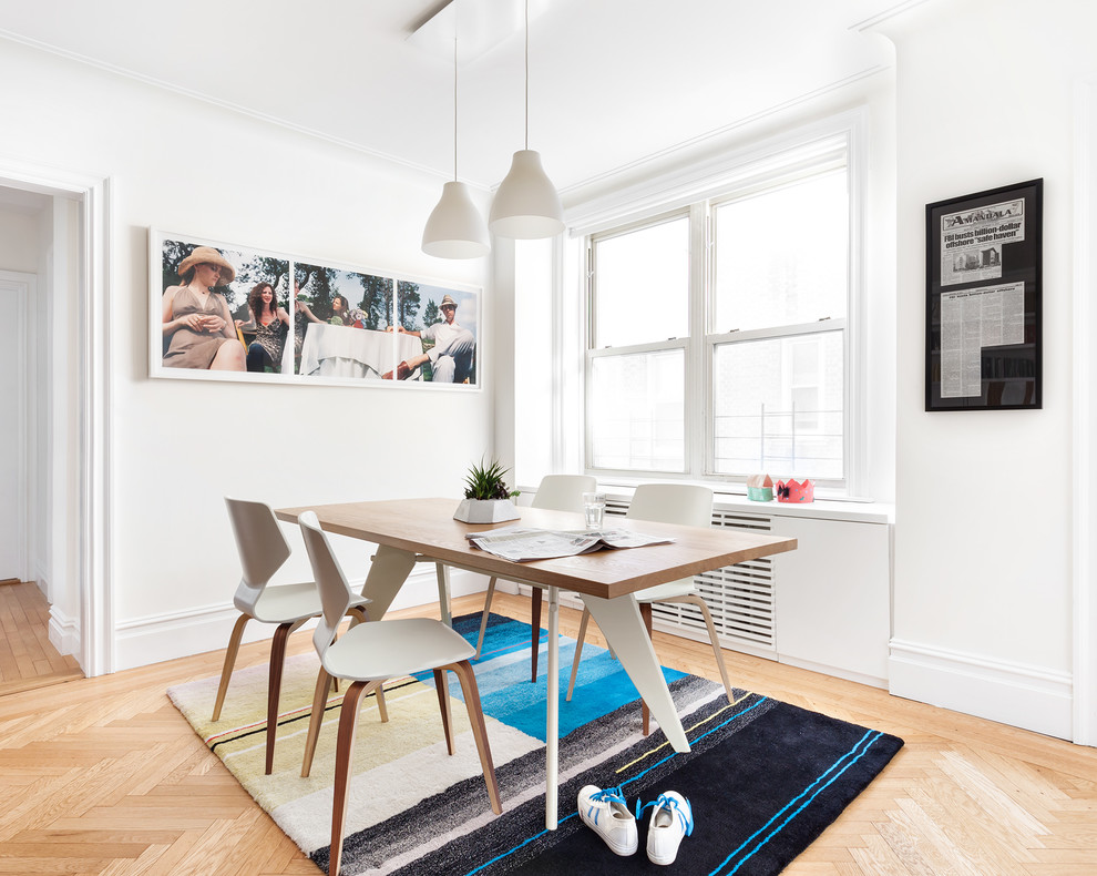 Inspiration for a small contemporary dining room in New York with white walls, light hardwood floors and brown floor.