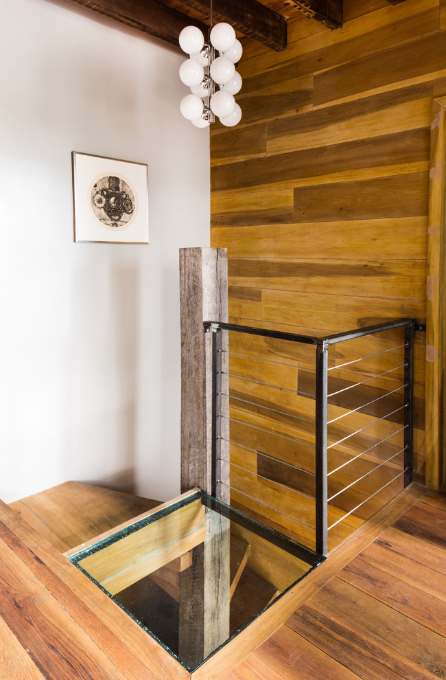 Inspiration for an industrial wood spiral staircase in New York with wood risers and metal railing.