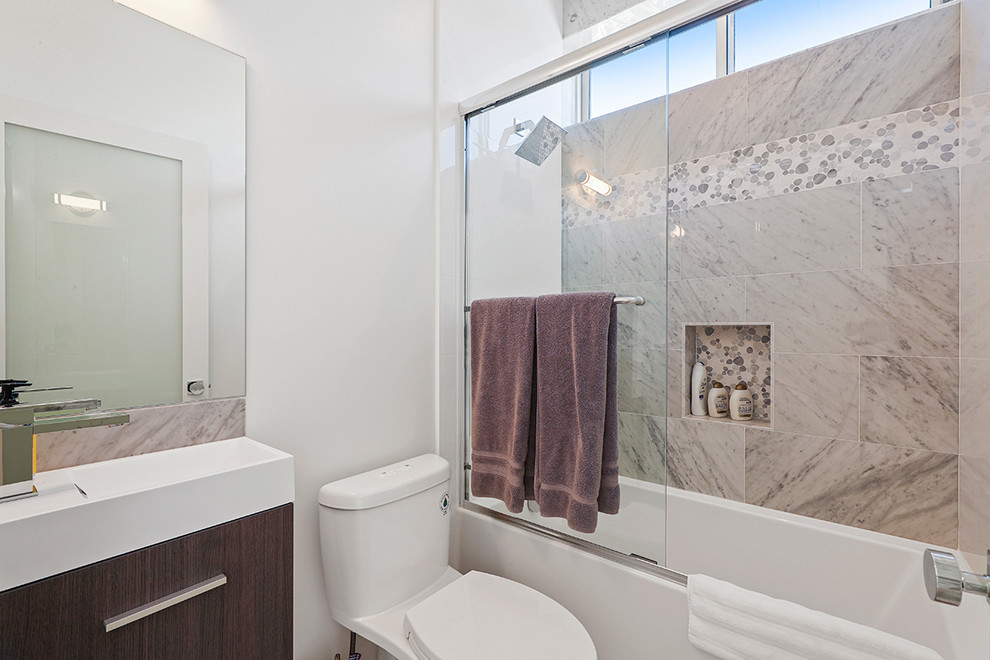 This is an example of a small modern bathroom in Los Angeles with flat-panel cabinets, dark wood cabinets, an alcove tub, a one-piece toilet, multi-coloured tile, marble, white walls, porcelain floors, a console sink, engineered quartz benchtops, grey floor and a sliding shower screen.