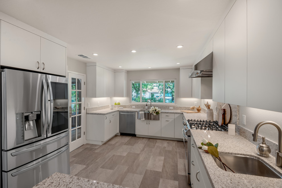 Inspiration for a mid-sized modern u-shaped separate kitchen in San Francisco with a farmhouse sink, flat-panel cabinets, white cabinets, quartzite benchtops, grey splashback, a peninsula, grey floor, grey benchtop, wood, stone slab splashback, stainless steel appliances and vinyl floors.