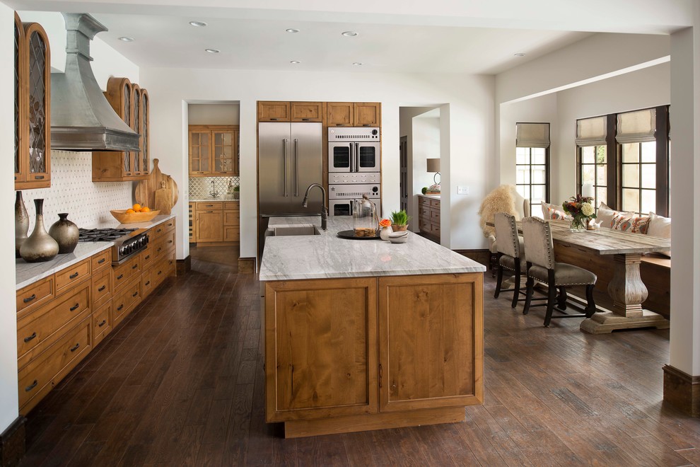 Design ideas for a country galley eat-in kitchen in Atlanta with a farmhouse sink, recessed-panel cabinets, medium wood cabinets, marble benchtops, stainless steel appliances, medium hardwood floors and with island.