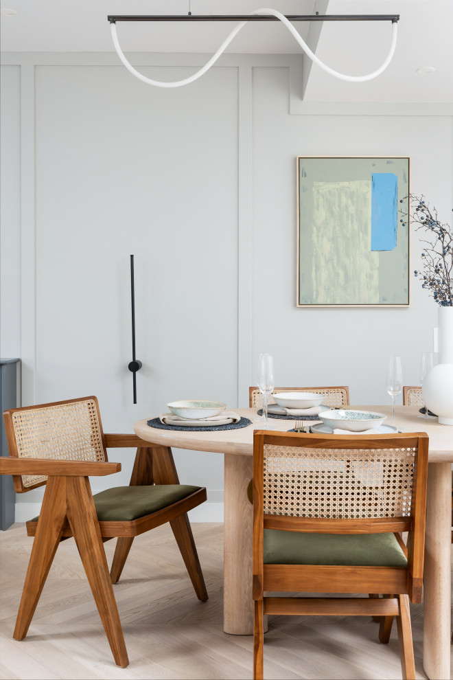 Ispirazione per una sala da pranzo contemporanea con pareti bianche, parquet chiaro, pavimento beige e pannellatura