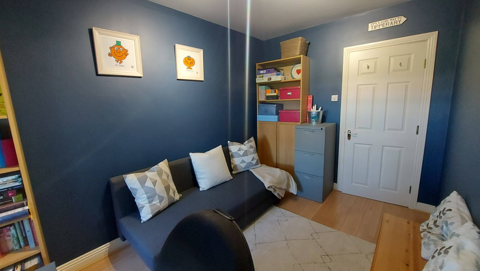 ダブリンにあるお手頃価格の小さなコンテンポラリースタイルのおしゃれな書斎 (青い壁、ラミネートの床、自立型机、茶色い床) の写真