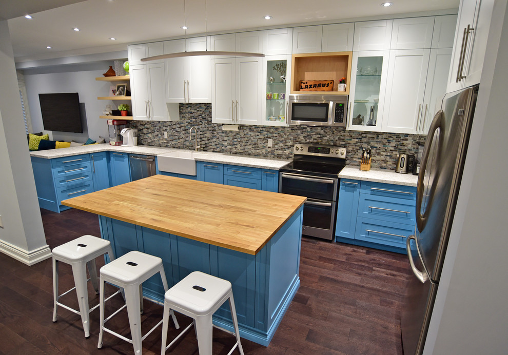 Kitchen - mid-sized transitional porcelain tile kitchen idea in Toronto with a farmhouse sink, recessed-panel cabinets, medium tone wood cabinets, quartz countertops, multicolored backsplash, glass tile backsplash, stainless steel appliances, an island and white countertops
