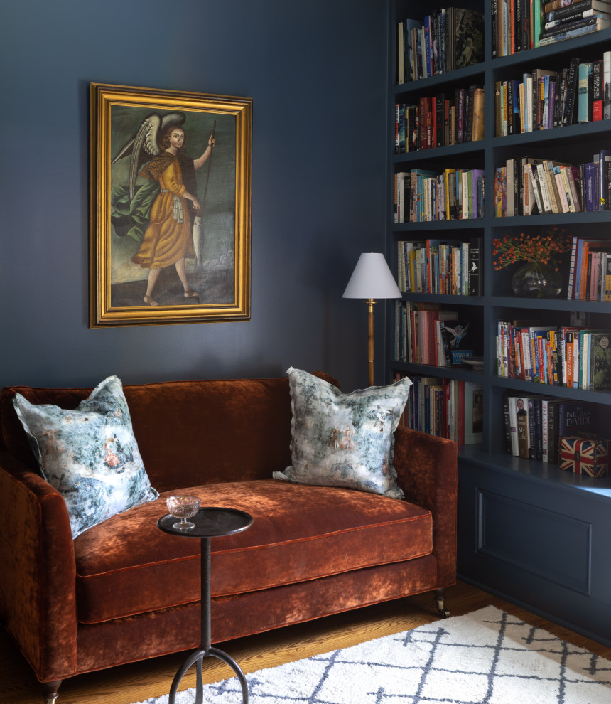 Aménagement d'un petit bureau éclectique avec une bibliothèque ou un coin lecture et un mur bleu.