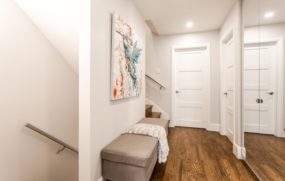 Esempio di un ingresso o corridoio minimal di medie dimensioni con pareti bianche, pavimento in legno massello medio e pavimento marrone