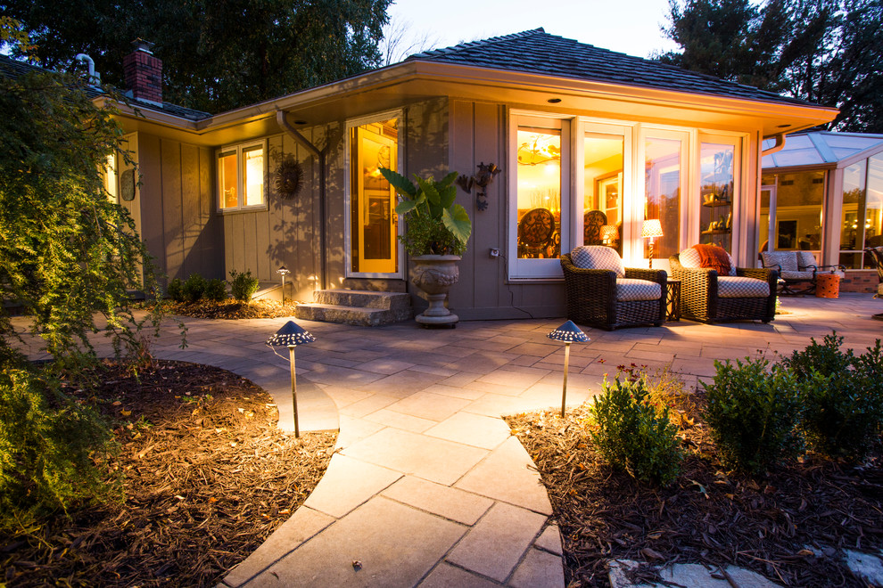 This is an example of a transitional backyard stone water fountain landscape in Omaha.