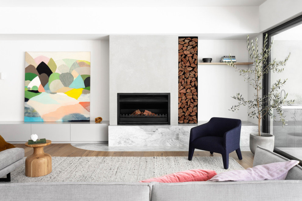 Contemporary open concept living room in Melbourne with white walls, medium hardwood floors, a standard fireplace and brown floor.