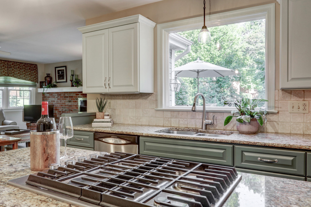 Mid-sized transitional l-shaped ceramic tile and beige floor eat-in kitchen photo with a double-bowl sink, raised-panel cabinets, green cabinets, granite countertops, beige backsplash, ceramic backsplash, stainless steel appliances, an island and beige countertops