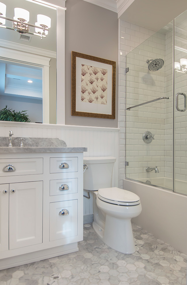 Inspiration for a mid-sized contemporary 3/4 bathroom in New York with a console sink, beaded inset cabinets, white cabinets, marble benchtops, a freestanding tub, an alcove shower, a one-piece toilet, white tile, ceramic tile, grey walls and ceramic floors.